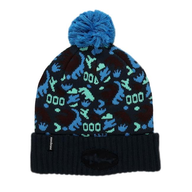 The Patagonia Black and Blue Pom Beanie features a blue pom-pom, patterned blue, teal, and black shapes, a folded ribbed brim, a black patch, and is made from recycled polyester for warmth and sustainability.