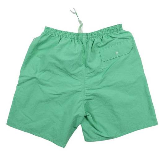 The Patagonia Green Baggies Long Shorts feature quick-drying fabric, an elastic waistband, white drawstring, and a single back pocket with a button flap.