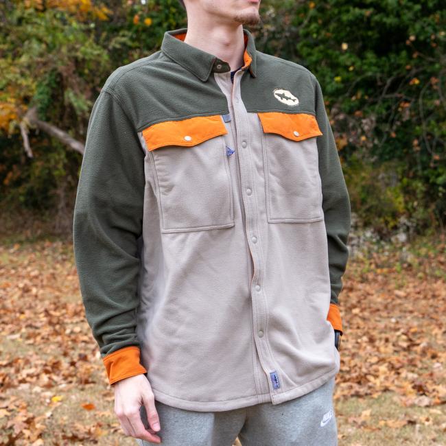 A person stands outdoors among autumn leaves wearing the Patagonia M Grey Two Pocket Button Down by Patagonia, a long-sleeved shirt with button closures and chest pockets.