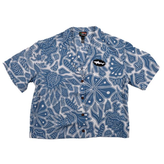 The Patagonia W Blue Threads Button Up is a women's shirt made from a hemp and organic cotton blend, with a blue and white floral pattern and shark patch on the chest. Part of the Dogfish Head x Patagonia collection.