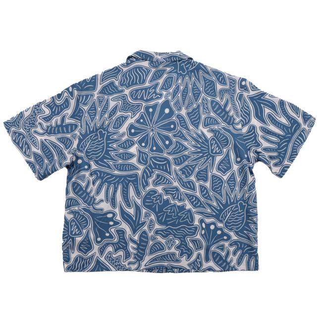 The Patagonia W Blue Threads Button Up by Patagonia is a women’s blue and white shirt, made from a hemp organic cotton blend, featuring an abstract floral and leaf pattern. Shown laid flat with the back side facing up.
