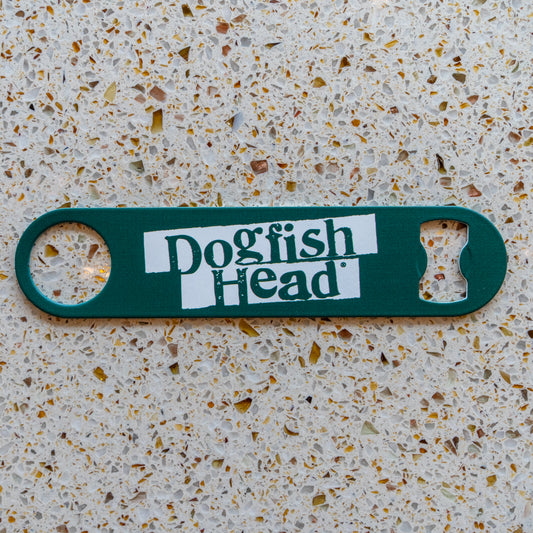 A green Merchtank Bartender Opener with white branding rests on a speckled beige countertop.