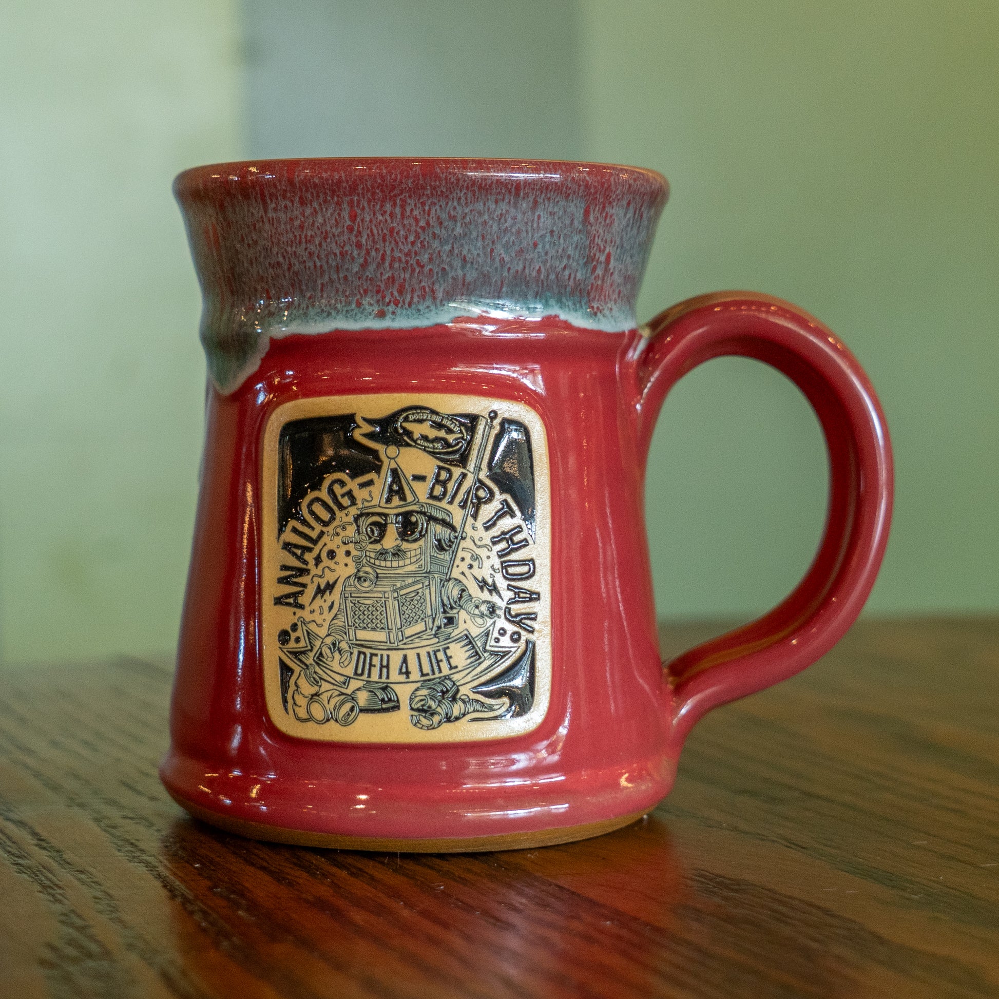 A pink Analog Splitrock ceramic mug by Deneen Pottery with a wide base, handle, and decorative plaque reading “Analog-A-Birthday, OGH 4 Life,” plus a robot holding a record player—perfect for showing off true brewery pride.