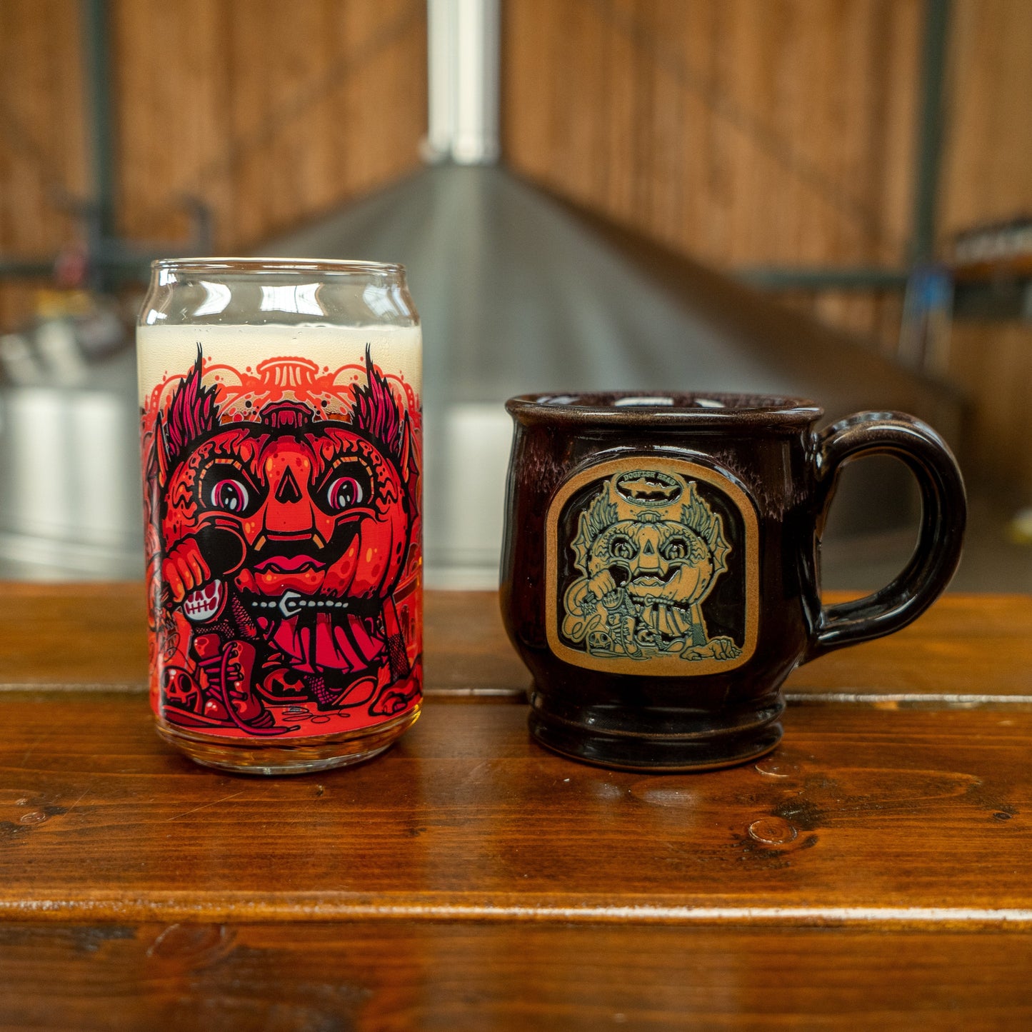 Image of Punkin can glass and mug next to each other. Can glass features red punkin artwork and mug features the same in brown and black.