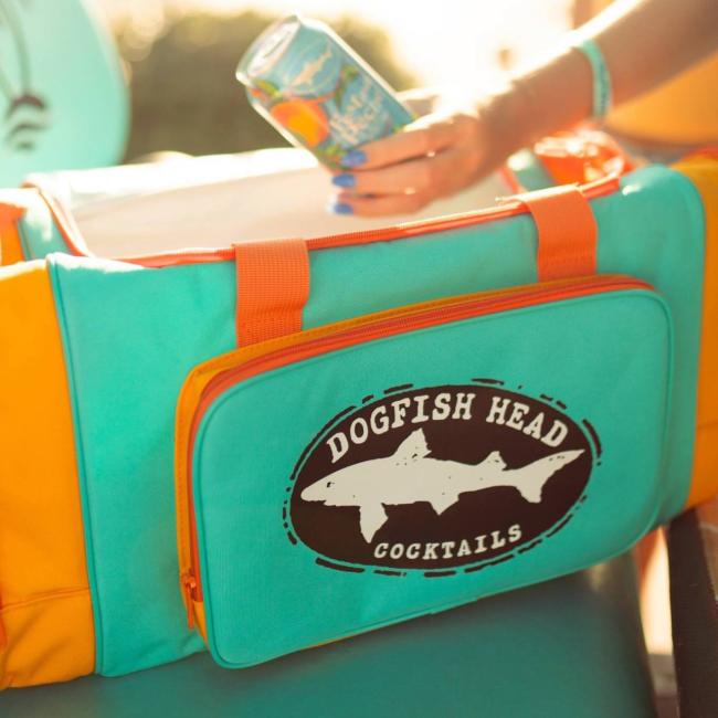 Blue cooler duffle that are orange on the sides. The center pocket on the front features a black Dogfish Head shark and shield logo.