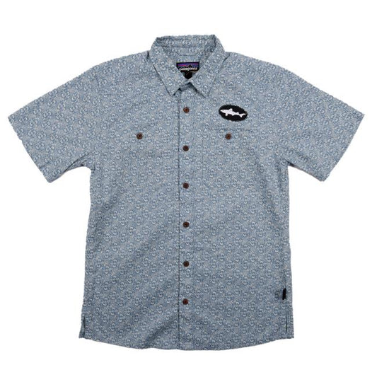 A Patagonia Slate Blue Button Up made from soft hemp organic cotton, featuring a subtle repeating pattern, two chest pockets, brown buttons, and a black fish-shaped patch on the left chest.