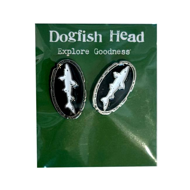Black and white Dogfish Head shark and shield logo shaped earrings in a green packaging.