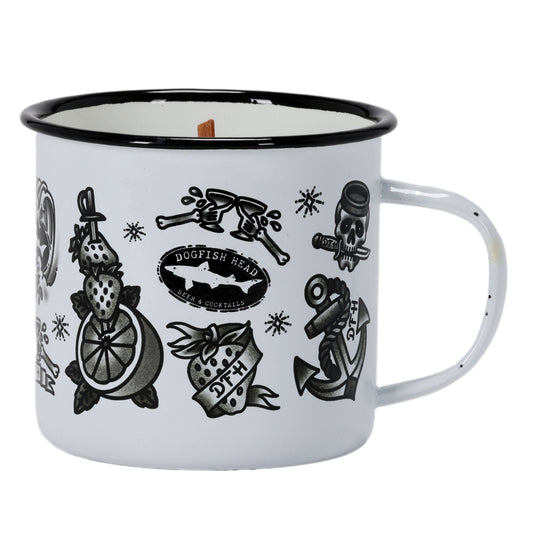 The Tattoo Enamel Mug Candle by Unwined Candles, LLC features tattoo-style art—anchor, skull, citrus, and more—on a white mug with black rim. Reuse the enamel mug for camping or collecting after the candle is finished.