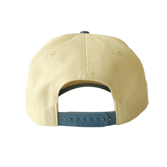 Back view of cream hat with blue snapback. 