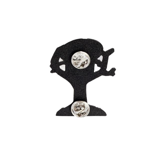 The Treehouse Pin by Arrasmith Promotions LLC is a black metal accessory shaped like a tree with a figure climbing it, featuring two silver clasps on the back and displayed on a white background.