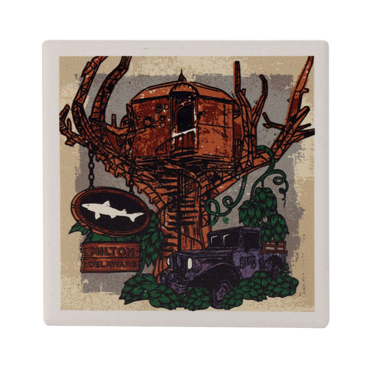 The Truck Treehouse Ceramic Coaster by Paint the Town, Inc. features a rustic, steampunk treehouse with a round wooden structure, a vintage truck below, and a Milton Delaware shark sign—perfect for beer lovers.