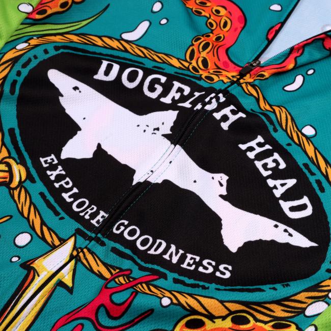 The Voler Underwater Bike Jersey features a colorful fabric with two white fish silhouettes, the words DOGFISH HEAD and EXPLORE GOODNESS in a rounded black logo, and ocean-themed illustrations—perfect for cycling.