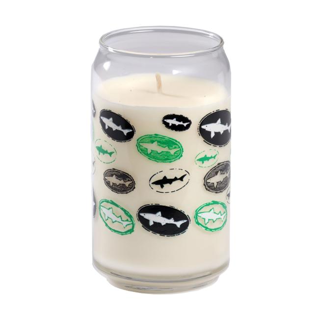 The Vanilla Core Logo Candle by Unwined Candles, LLC is a white vanilla-scented candle in a reusable soda can-shaped glass with black, green, and gray oval shark silhouette designs.