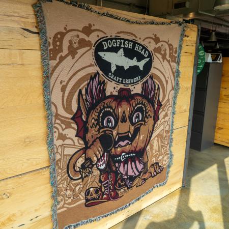 Blanket featuring pumpkin artwork and Dogfish Head shark and shield logo.