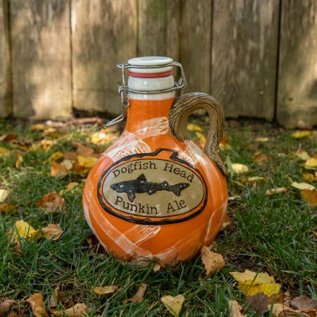 Orange growler with Dogfish head logo centered with writing "Dogfish Head Punkin Ale". Growler handle is brown made to look like a tree branch.