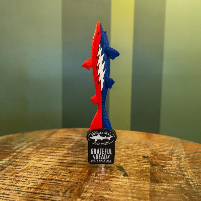 Dogfish Head Shark Tap handle, red and blue featuring Grateful Dead lightening bolt, text and Shark & Shield logo.