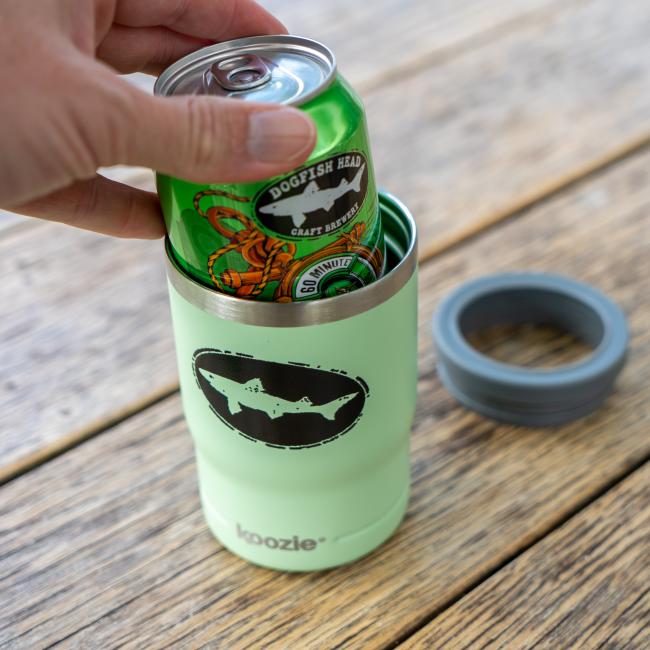 Dogfish Head 12oz sage green can cooler shown with its lid and screw-on ring removed, highlighting its dual function as a tumbler or can insulator. Shown with a can being dropped into it.
