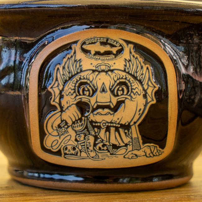 Close-up of front view of crock which features brown and black Punkin artwork.