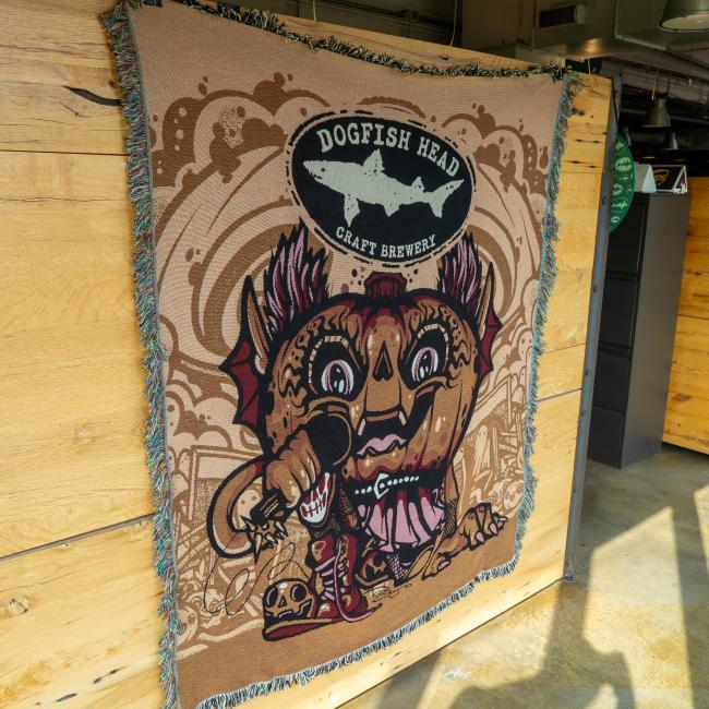 Blanket featuring pumpkin artwork and Dogfish Head shark and shield logo.