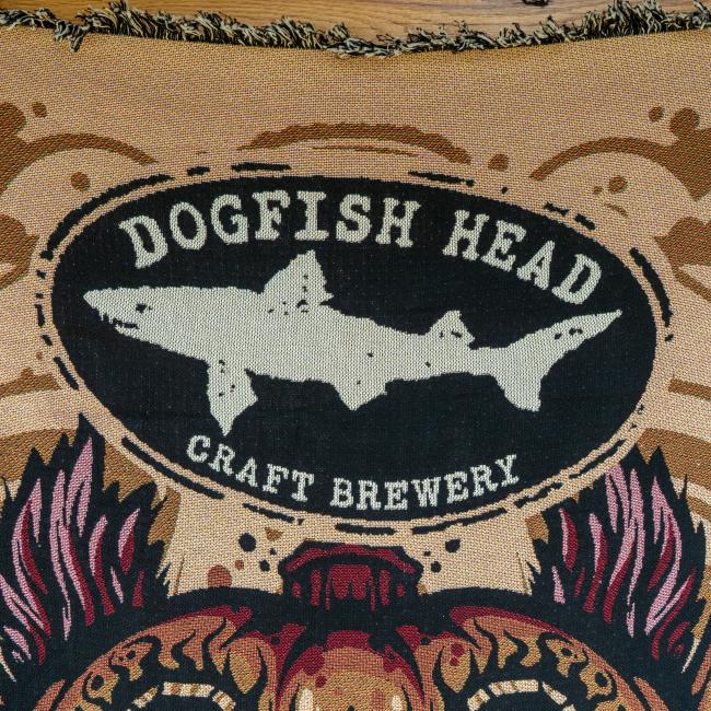 Close-up of Dogfish Head shark and shield logo.