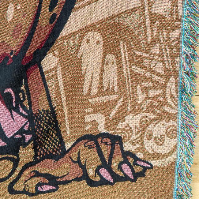 Close-up of background artwork on blanket, features imagery of ghosts and pumpkins.