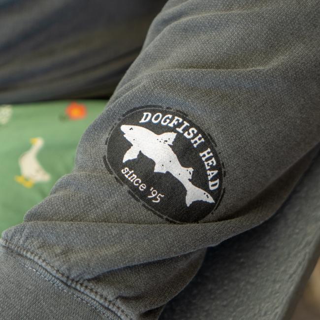 Close-up of Dogfish Head shark and shield logo featured on left sleeve.