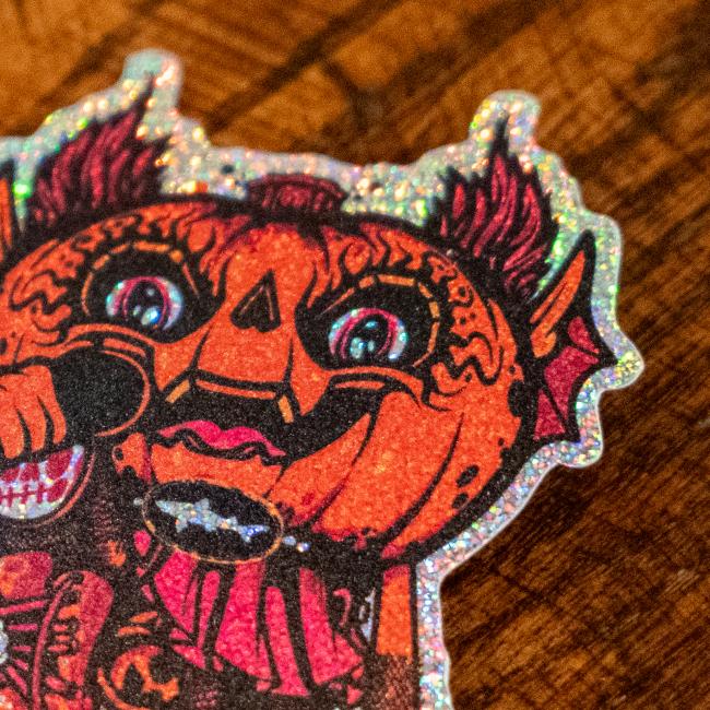 Sticker features orange/red Punkin artwork with a mic in its hand. Sticker is outlined with glitter.