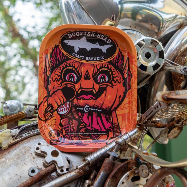 Orange tray covered in Punkin artwork, with Dogfish Head shark and shield logo on top.