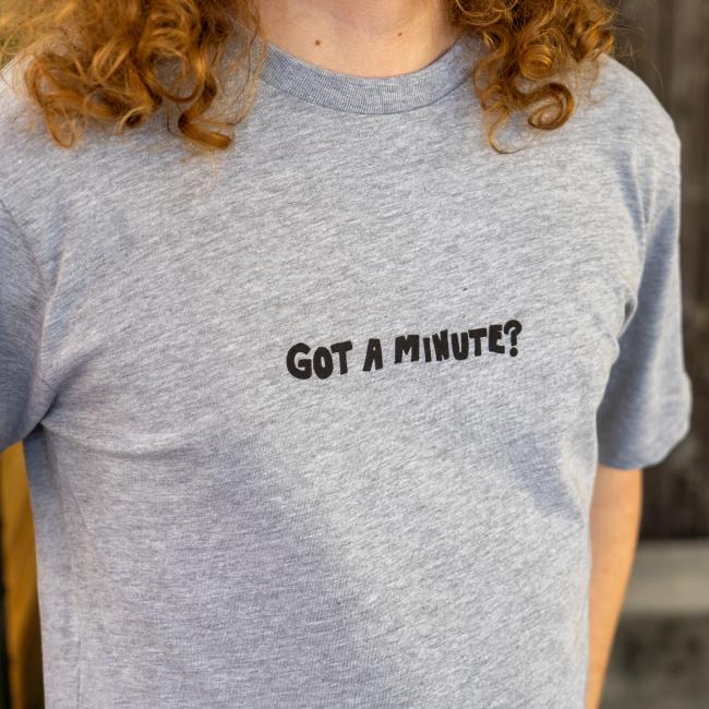 Close-up of the front of tee being modeled, features writing 
