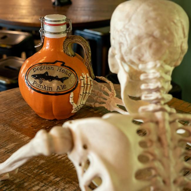 Orange growler with Dogfish head logo centered with writing 